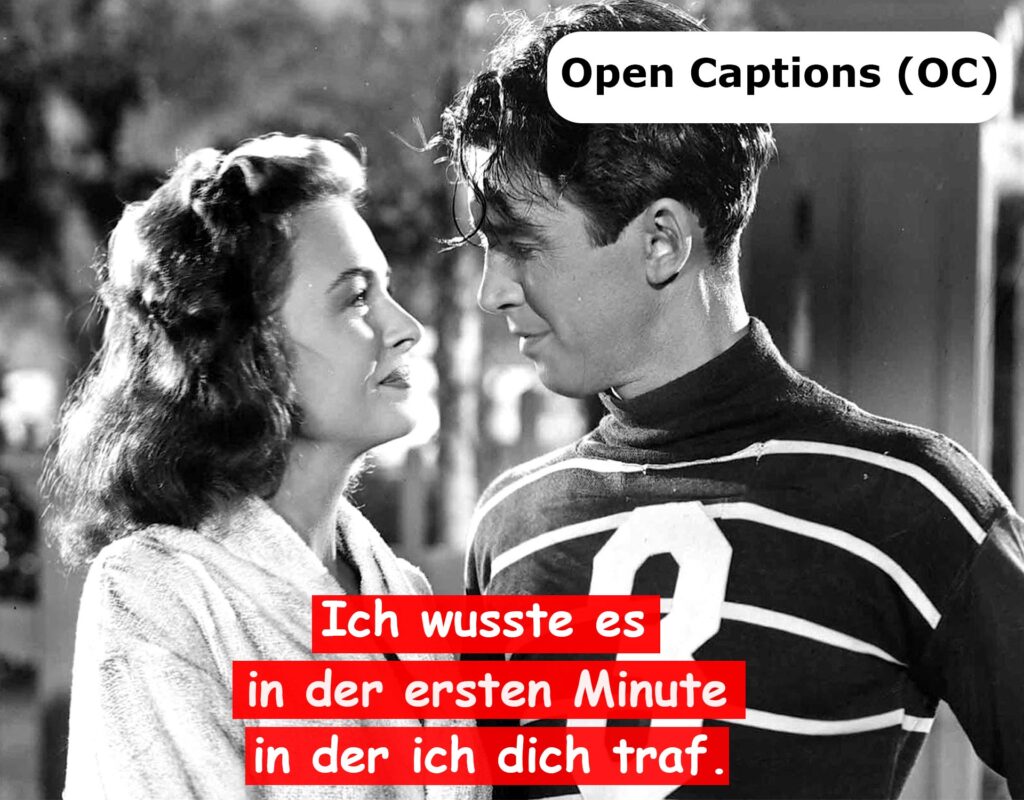 Eine klassische Filmszene mit Untertiteln im Open-Captions (OC)-Format. Der weiße Text erscheint in drei Zeilen auf roten Balken und ist in einer verspielten, dekorativen Schrift gestaltet, die sich vom Hintergrund abhebt.